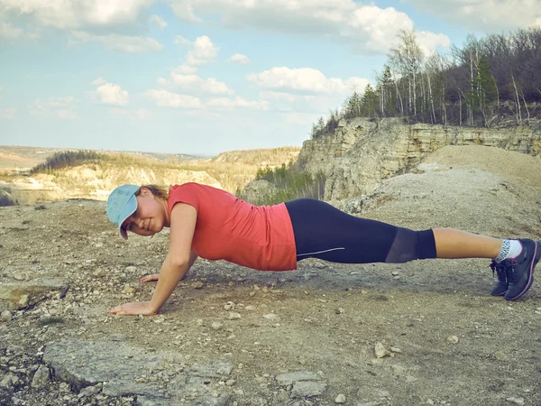 Jonge vrouw pushups buiten in de natuur. — Stockfoto