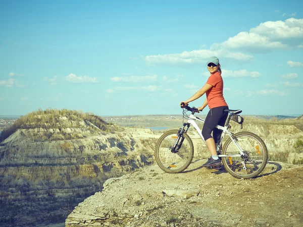 Menina uma bicicleta nas montanhas . — Fotografia de Stock