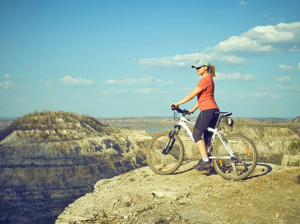 Menina uma bicicleta nas montanhas . — Fotografia de Stock