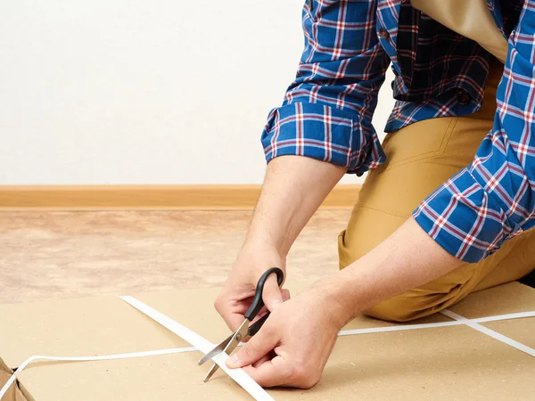 El hombre abre la caja con muebles . — Foto de Stock