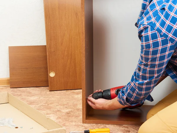 El hombre recoge muebles . — Foto de Stock