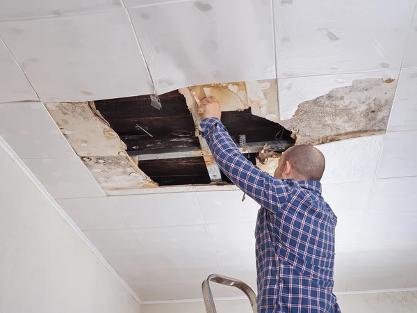 Man repairing collapsed ceiling. — Stock Photo, Image
