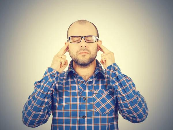 Man met bril zijn hoofd met zijn handen te houden. — Stockfoto