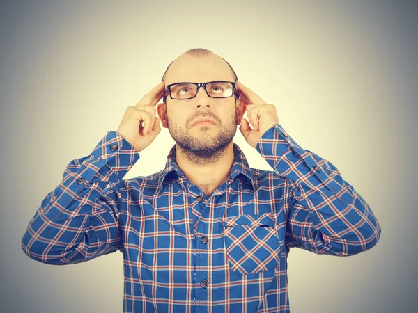 Man met bril zijn hoofd met zijn handen te houden. — Stockfoto