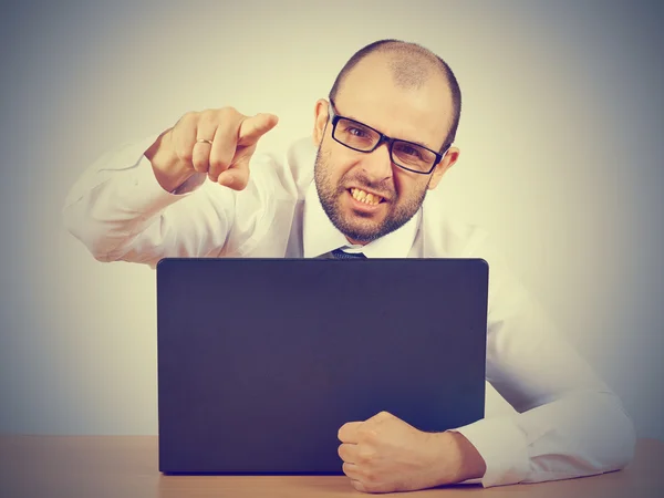 Hombre de negocios enojado sentado en su escritorio y gritando — Foto de Stock