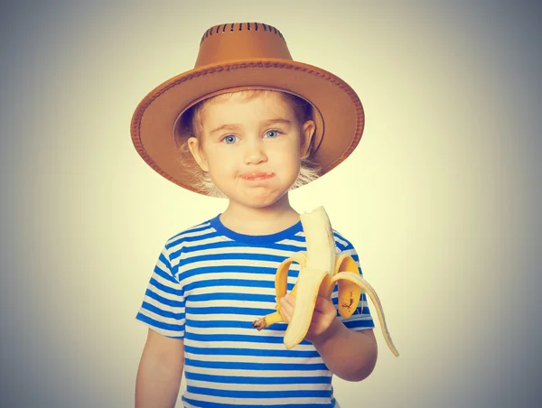 Kleines lustiges Mädchen isst Banane. — Stockfoto