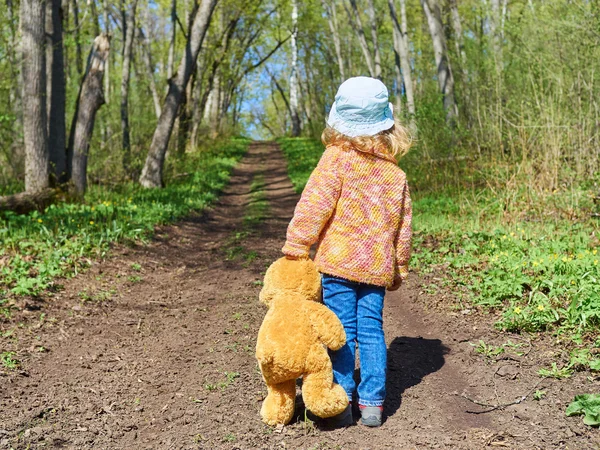 Çocuk oyuncak ayı ile yolda yürüyor — Stok fotoğraf