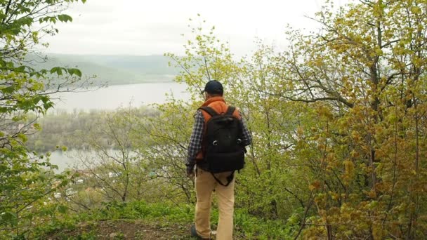 Mann mit Rucksack fotografiert mit Fotokamera natürliche Landschaft — Stockvideo