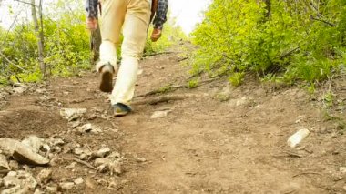 Bir adam bir sırt çantası ile orman yolun yokuş yukarı yürümek. Hiking.