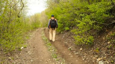 Orman yolu yürüyüş bir sırt çantası ile turist adam.