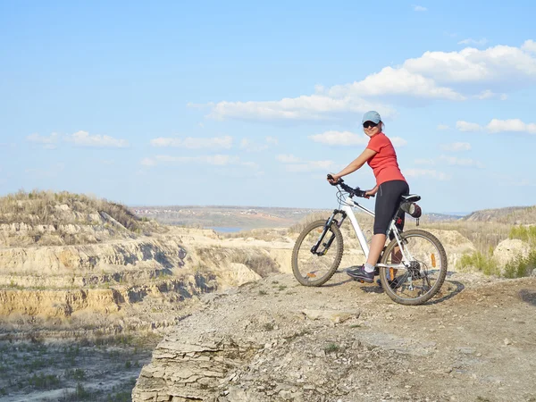 Menina uma bicicleta nas montanhas . — Fotografia de Stock