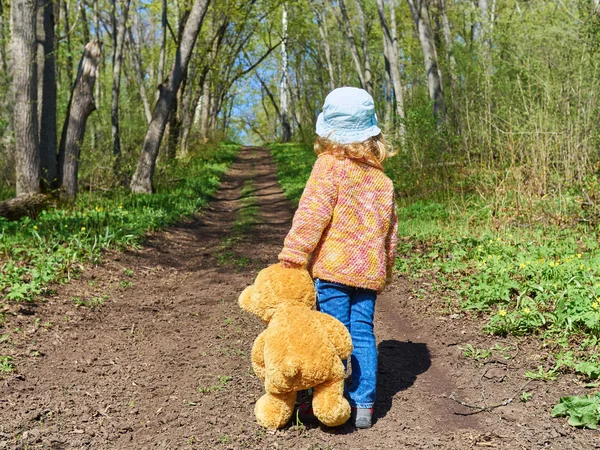 Bambino sta camminando lungo il sentiero con orsacchiotto — Foto Stock