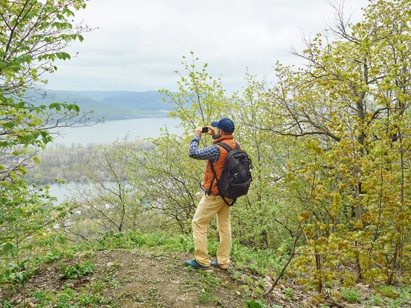 Homem fotografado em uma paisagem natural smartphone — Fotografia de Stock