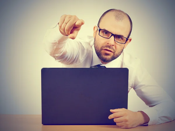 Angry  businessman sitting at his desk Stock Picture