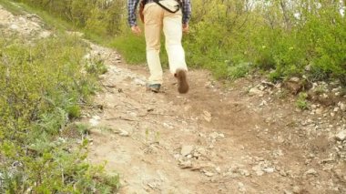 Bir adam bir sırt çantası ile orman yolun yokuş yukarı yürümek. Hiking.