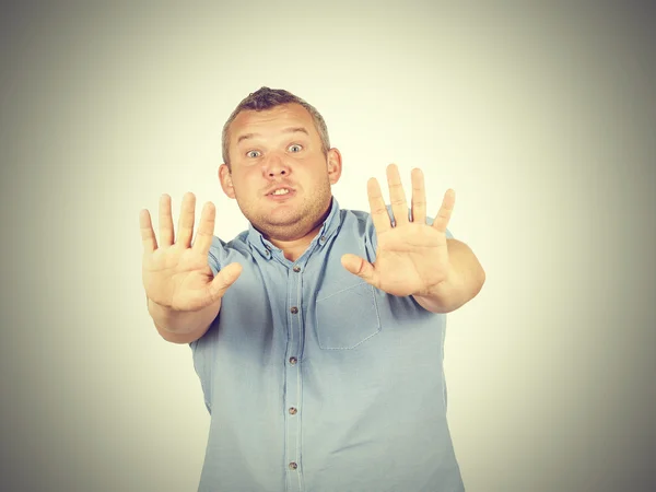 Hombre gordo mirando sorprendido asustado tratando de protegerse — Foto de Stock