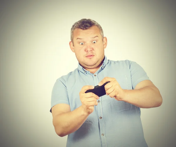 Homem gordo olha para o telefone . — Fotografia de Stock