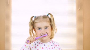 Küçük kız dişlerini fırçalama. dişlerle ilgili sağlık bilgisi. mutlu küçük kız onun diş fırçalama