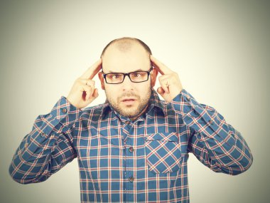 Başını elleri ile tutarak gözlüklü adam.