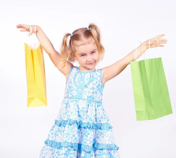 Çocuk alışveriş. küçük kız holding alışveriş torbaları — Stok fotoğraf