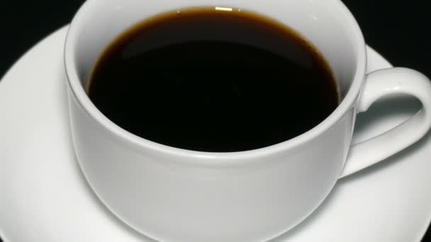 Taza blanca café negro sobre fondo negro — Vídeos de Stock