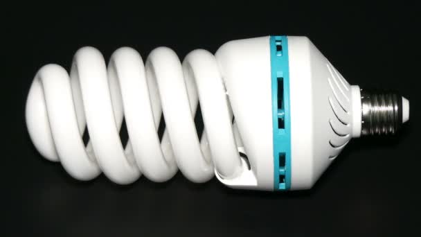 Lámpara de ahorro de energía aislada sobre fondo negro . — Vídeo de stock