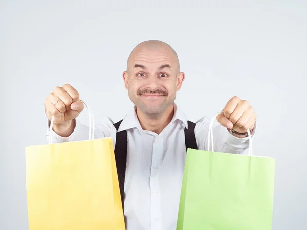 Homem caucasiano careca, com sacos de papel de compras coloridos — Fotografia de Stock