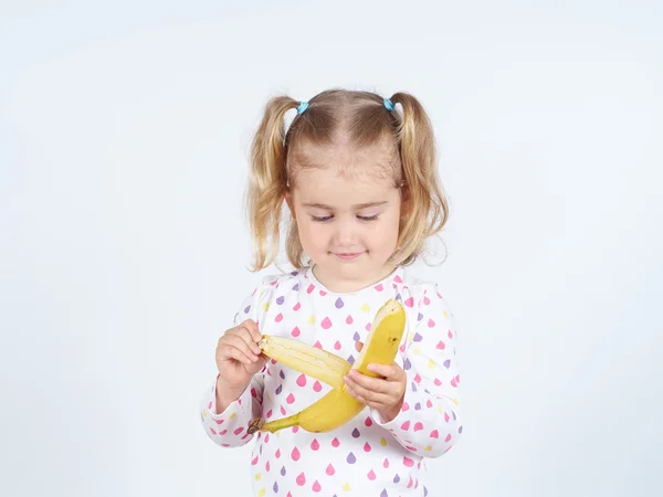 Niña comiendo un plátano fresco . Imágenes De Stock Sin Royalties Gratis