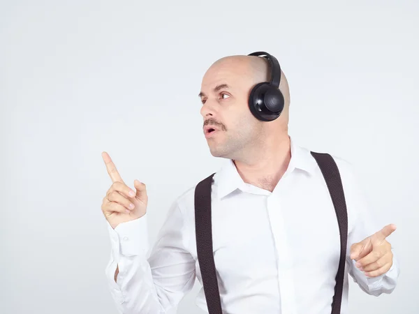 Mustache businessman listening to music on headphones and sings Royalty Free Stock Photos