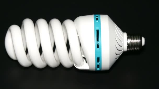 Energy saving lamp isolated on black background. — Stock Video