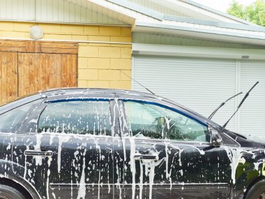 Adam eve yakın onun siyah araba yıkama.