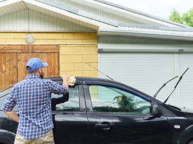 Adam eve yakın onun siyah araba yıkama.