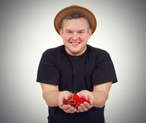 Jeune homme gras avec du chili dans les mains . — Photo