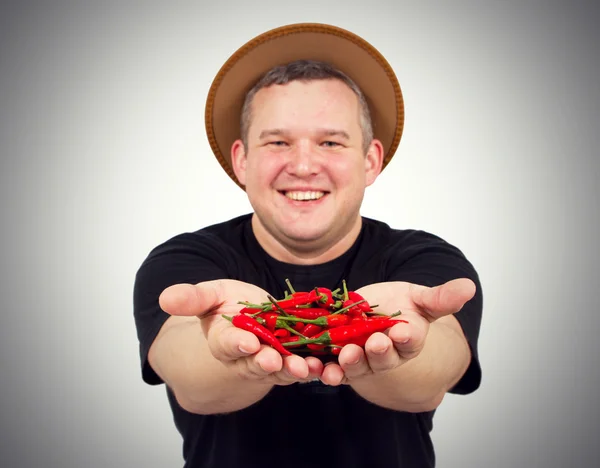 Jeune homme gras avec du chili dans les mains . — Photo