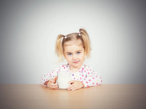 Niña feliz con un vaso de leche . Imagen De Stock