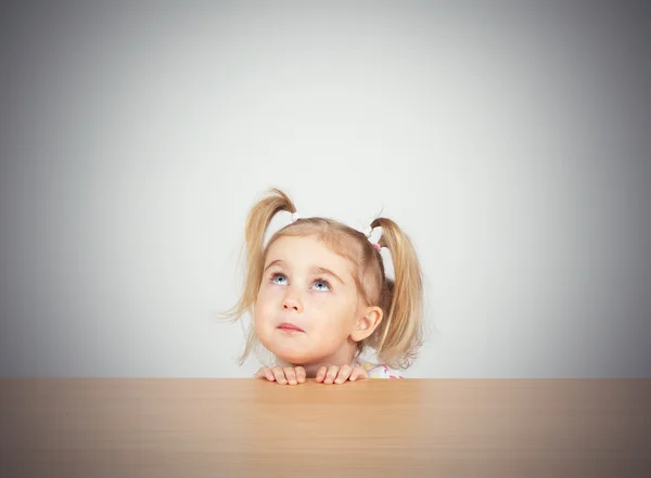 Little girl in casual clothes looking up and thinking Stock Picture