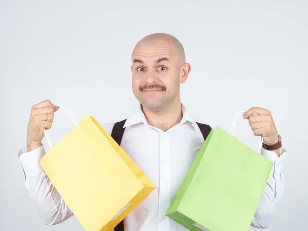 Homem caucasiano careca, com sacos de papel de compras coloridos — Fotografia de Stock