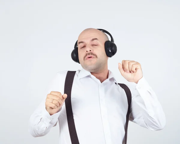 Mustasch affärsman lyssna på musik på hörlurar och sjunger Stockbild