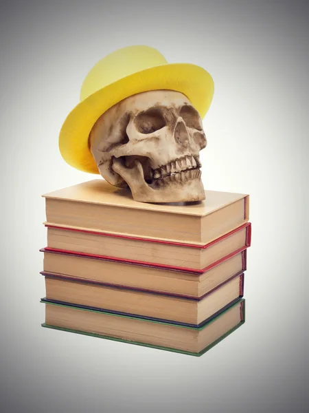 Koponya sárga kalapban a könyvek — Stock Fotó