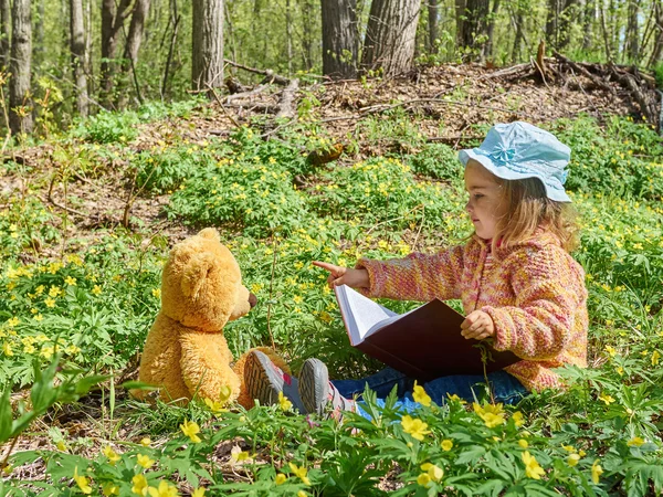 Leuk meisje lezen boek Teddy bear — Stockfoto