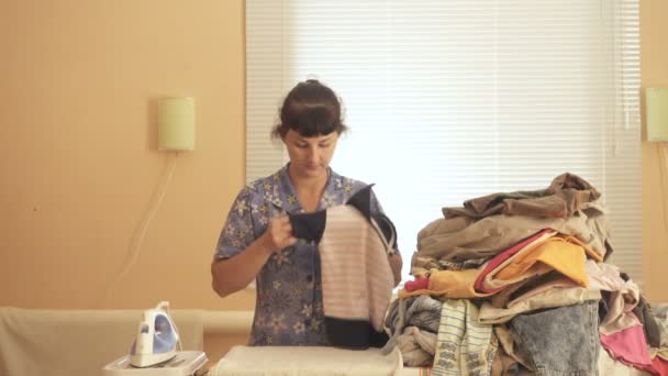 Young Caucasian woman ironed clothes in the room near the window. — Stock Footage Young Caucasian woman ironed clothes in the room near the window. Royalty Free Stock Video