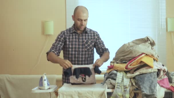 Caucasian man ironed clothes in the room near the window. Homework. — Stock Footage Caucasian man ironed clothes in the room near the window. Homework. Stock Video