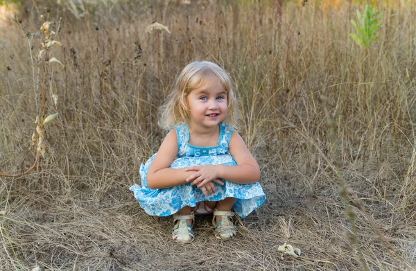 Petite fille assise dans l'herbe — Photo