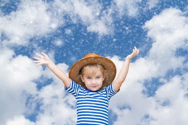 Liten flicka på bakgrund av himmel och snö. — Stockfoto