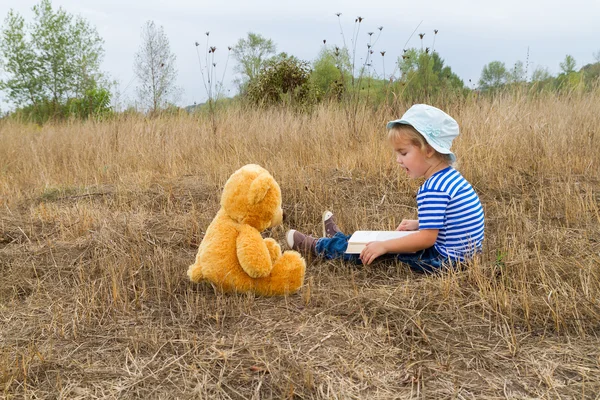 Söt flicka läsa bok Nalle — Stockfoto