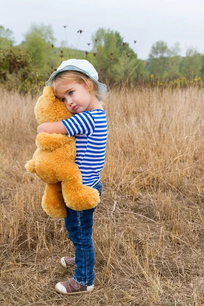 Bonito menina abraçando um grande ursinho de peluche — Fotografia de Stock