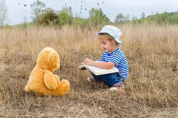 Carino ragazza lettura libro orsacchiotto — Foto Stock