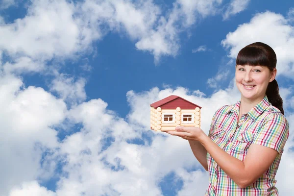 Young woman holding home isolated on a background of sky. — Stock Photo, Image