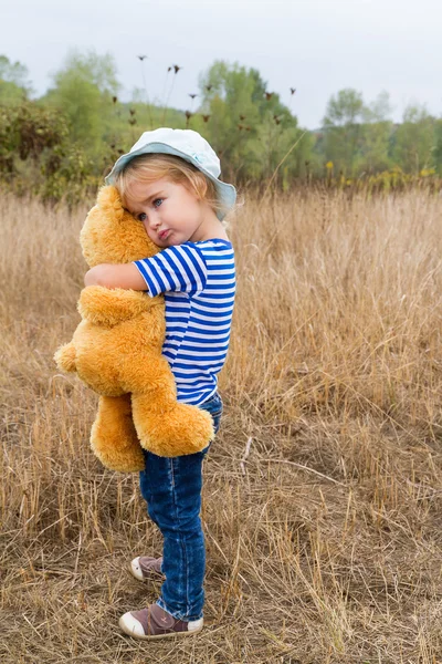 Bonito menina abraçando um grande ursinho de peluche — Fotografia de Stock