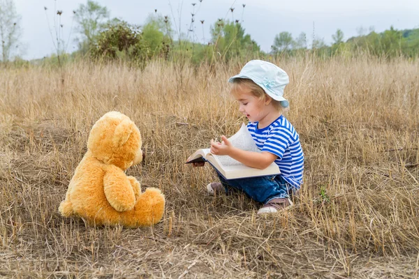 Sevimli kız kitap ayıcık okuma — Stok fotoğraf